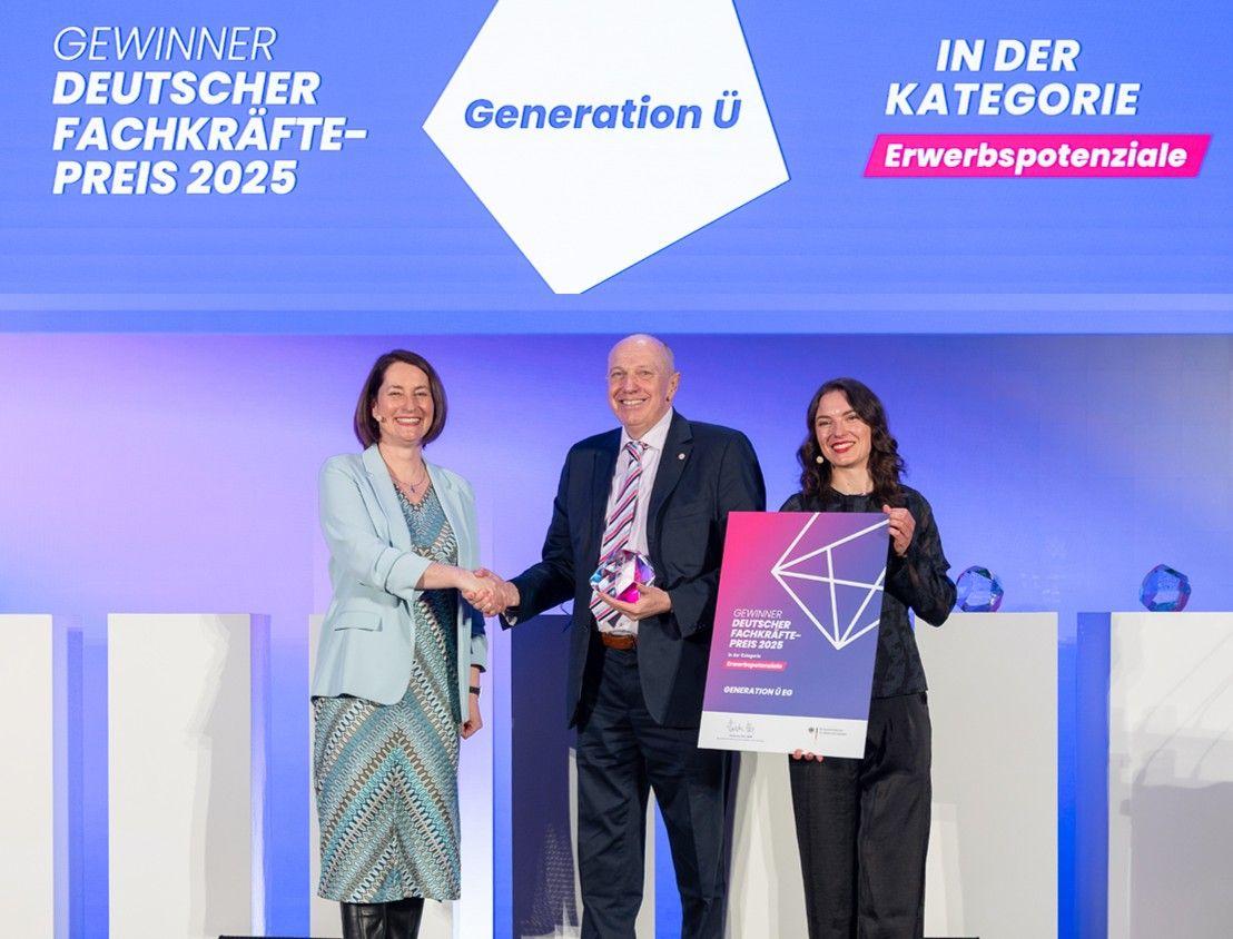 Manfred Kluth bekommt auf einer Bühne den Fachkräftepreis überreicht.