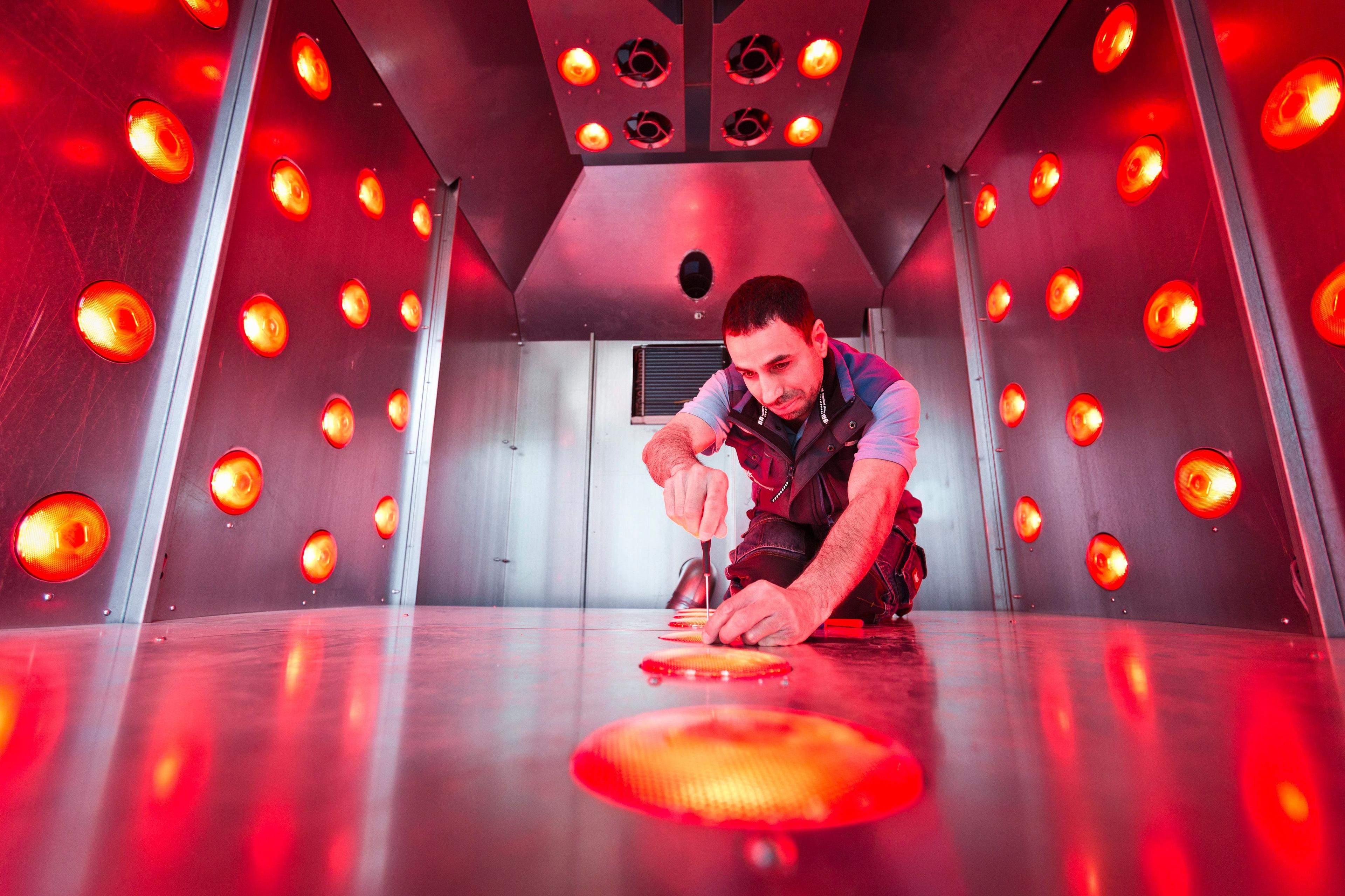 Ein Mitarbeiter von MK Technology beim Schrauben in einem Booster-Gerät.